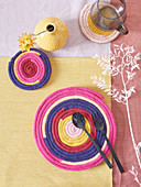Handmade coasters and mat made from knitted tubes made using knitting dolly