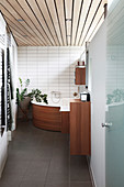 Corner bathtub with wood panelling in bathroom