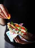 Hand sholding herby chicken gyros