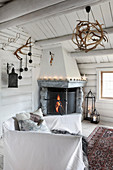 Open corner fireplace in rustic living room of log cabin