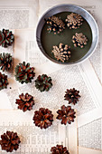 Dipping pine cones in green paint