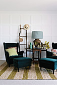 Wing chair with matching footstools, side table and ladder against white cassette wall