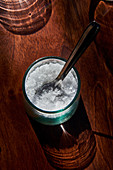 Salt flakes in a glass with a spoon