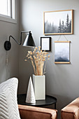 Black side table and wall-mounted lamp in corner