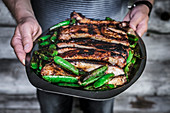 Grilled spare ribs served with pea pods