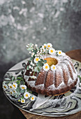 Zitronen-Ricotta-Kranzkuchen dekoriert mit Blüten