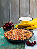 Homemade walnut tart with cherry jam, cherries, blueberries, vanilla curd on a wooden table
