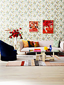 Polstersofa, Beistelltisch mit Rosenstrauß, Sessel und Couchtisch im Wohnzimmer mit Blumentapete, Bilder an der Wand