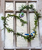 Heart shaped wreath with evergreen branches and bird figures