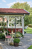 Shaded area with nostalgic garden chairs next to wooden house