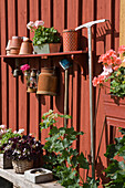 Workplace with collected plant pots, tools and flea market items on house wall