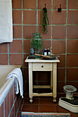 Old stool with drawer in bathroom with terracotta tiles
