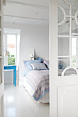 Glass door leading into bedroom with white floor and blue accents