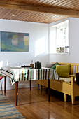 Striped tablecloth on table and yellow bench in dining room