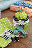 Sewing utensils in screw-top jar with pin cushion on lid