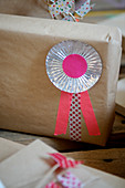 Rosette aus Pralinenförmchen und Masking Tape auf verpacktem Geschenk
