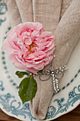 Rose und Libelle aus Perlen und Draht auf einer Stoffserviette