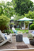 Deckchairs on paved terrace in summery garden