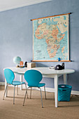Two blue chairs at oval table below map on blue wall