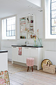 Narrow kitchen counter between two lattice windows in white kitchen