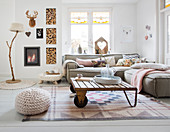 Sofagarnitur, Couchtisch und Kamin in hellem Wohnzimmer mit gestrickten und gehäkelten Accessoires