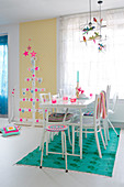 Colourful accessories in white dining room and Christmas tree made from wooden slats