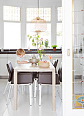 Boy sitting at table in white dining room with bay window