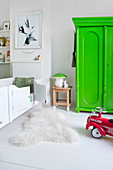 Weißes Kinderzimmer mit neongrünem Kleiderschrank