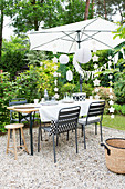 Set table, and umbrella and party decorations in a summer garden