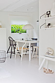 View of the dining area with various chairs in a white, open plan kitchen