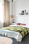 Green checked bedspread on double bed in bedroom