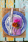 Napkin decorated with French marigold, phlox and verbena flowers on old plate