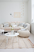 Couch, cushions, table and pouffe in festively decorated white living room