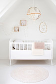 White cot below accessories on wall in attic room