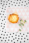 A muffin on a cloth napkin and a dotted background