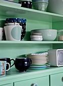 Various dishes on a mint green shelf