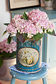 Pink-flowering hydrangea in old tin
