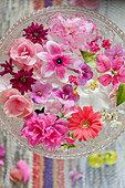 Pale pink and deep pink flowers floating in glass dish