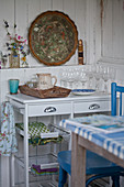 Drinking glasses on serving trolley against rustic, white board wall