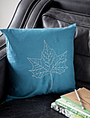 Embroidered cushion cover with leaf motif