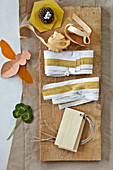 Fabric trimmings and ribbons on a wooden board with natural decorations