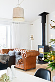 Living room with wood stove and leather couch decorated for Christmas