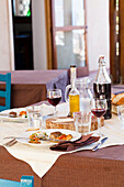 Gedeckter Tisch mit mediterranem Gericht und Rotwein, Sizilien, Italien