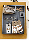Geschenkanhänger aus Papier mit Schmetterling-Motiven in einer Schachtel