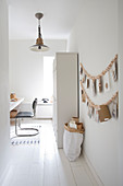 Study in white with a wooden pearl necklace as a wall decoration