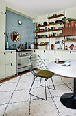 A wire chair at a dining table on a rug in an open-plan kitchen