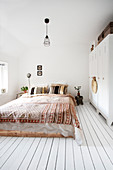Boho style bedroom with a locker as a wardrobe and wooden floor
