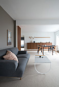 A grey upholstered sofa and a coffee table in a minimalist living area