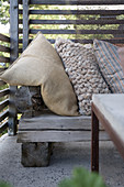 A rustic wooden bench with cushions on a terrace