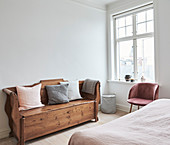 Rustic chest bench with pillows in a bright bedroom